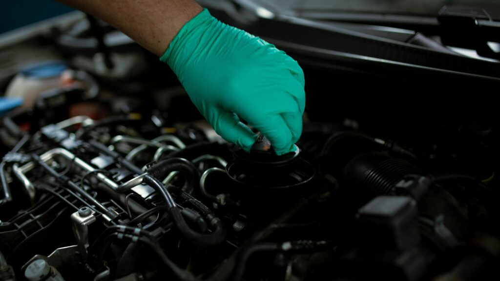 A Mechanic Opening the Oil Filler Cap of a Car Engine